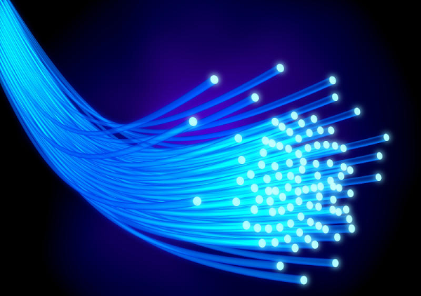 Various high-quality optical components, including lenses, waveguides, and fiber optic connectors, arranged on a workbench.